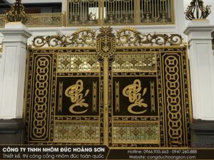 Cổng nhôm đúc 2 cánh kính, chữ Phúc trên nền vuông, hoa văn dây tiền đồng chạy dọc